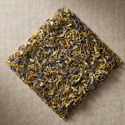 Dry herbs and flowers arranged in a diamond shape on a textured beige surface