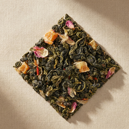 Tea leaves (oolong tea) with floral and fruit pieces on a textured beige surface